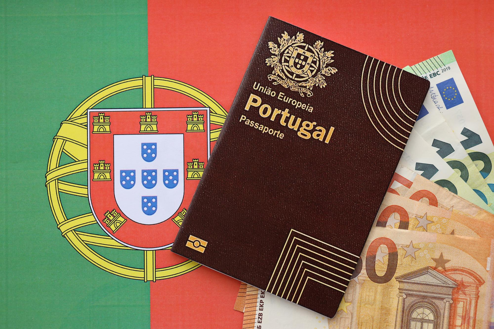 Passaporte vermelho de Portugal da União Europeia e dinheiro no fundo da bandeira em close