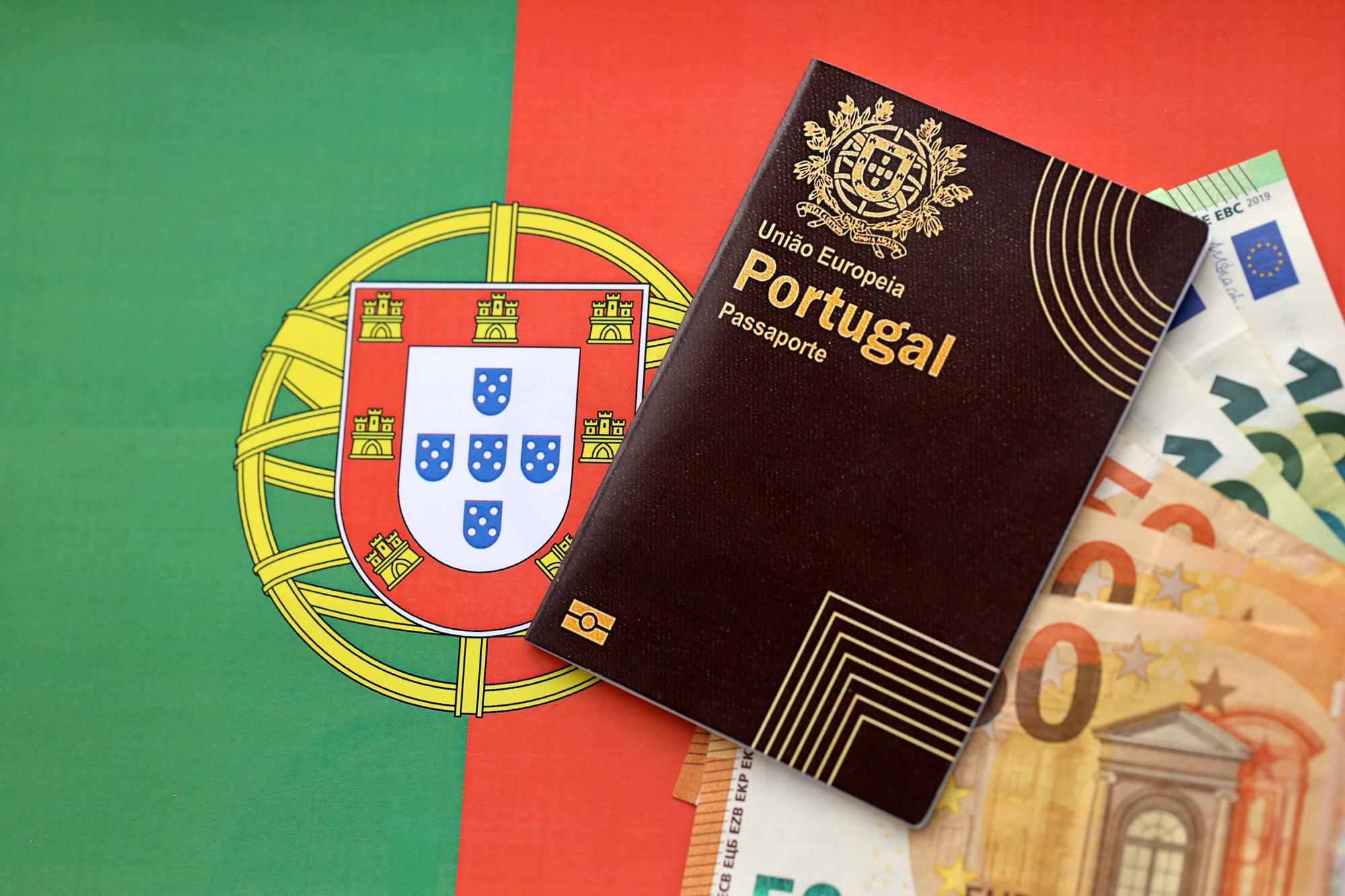 Passaporte português vermelho da União Europeia e dinheiro em fundo de bandeira em close-up