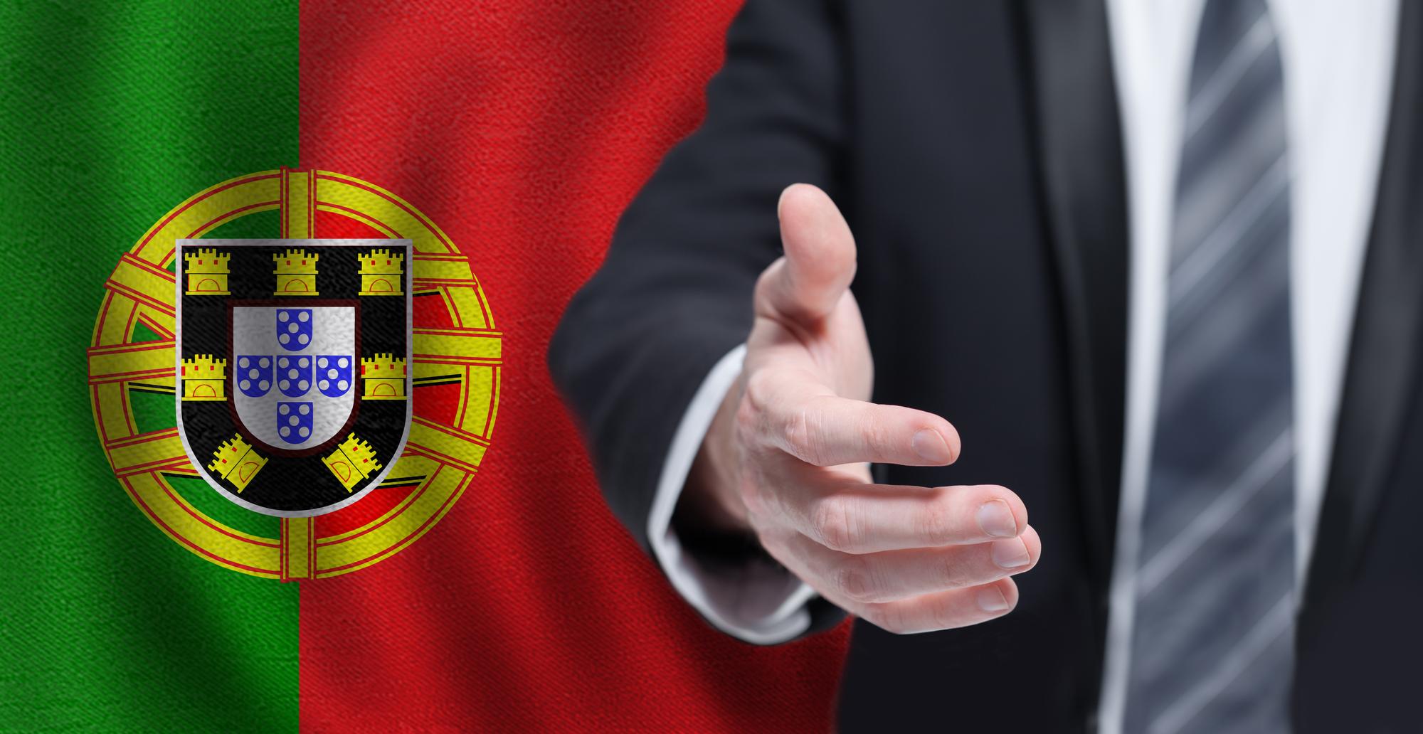 Política portuguesa cooperação empresarial e conceito de viagens Mão na bandeira de Portugal fundo