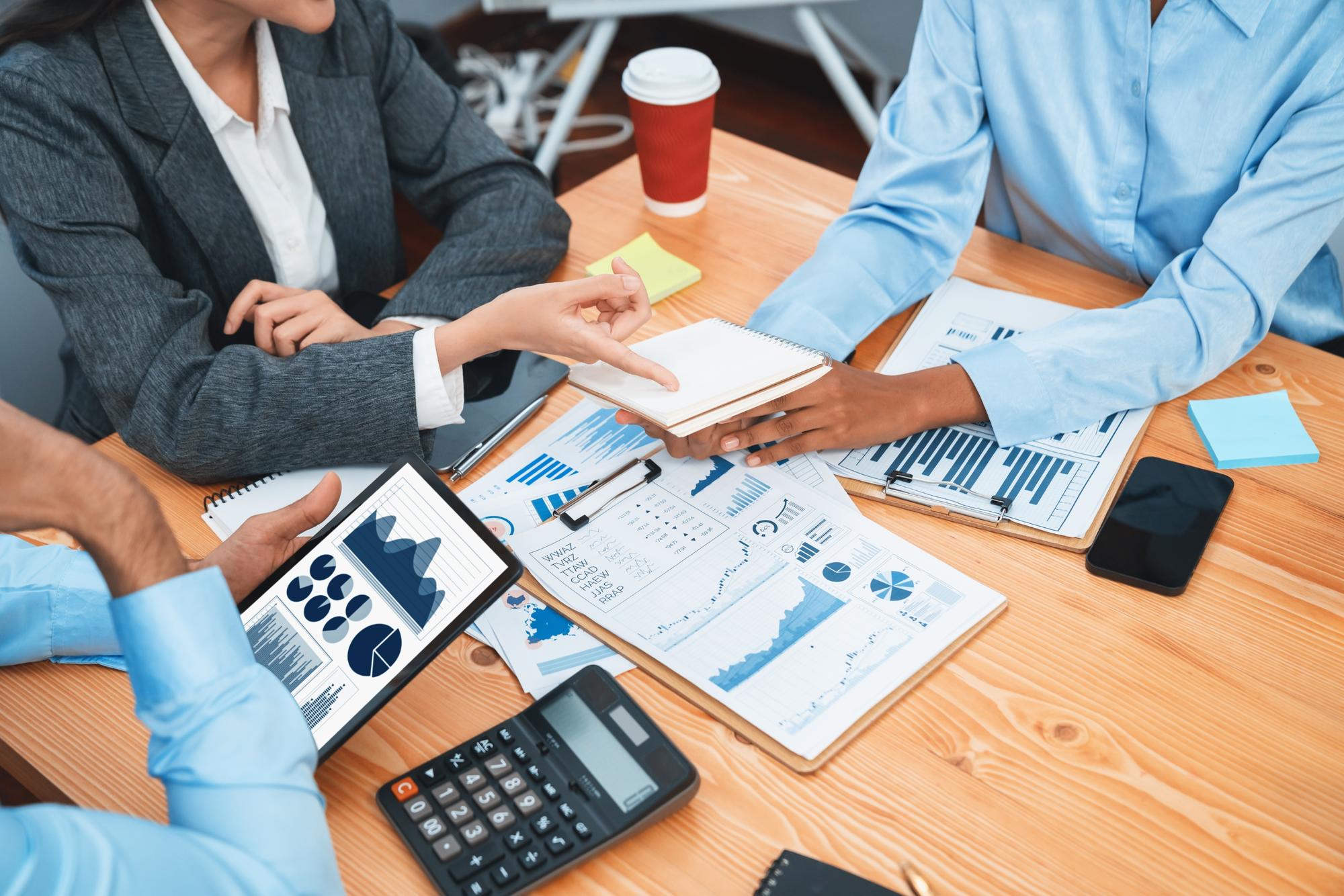 Equipe de analistas multirraciais usa a exibição de dados do painel de BI na tela do tablet para analisar o relatório financeiro Diversos empresários se reúnem sobre a análise de dados da FIntech para a indicação de marketing Concord