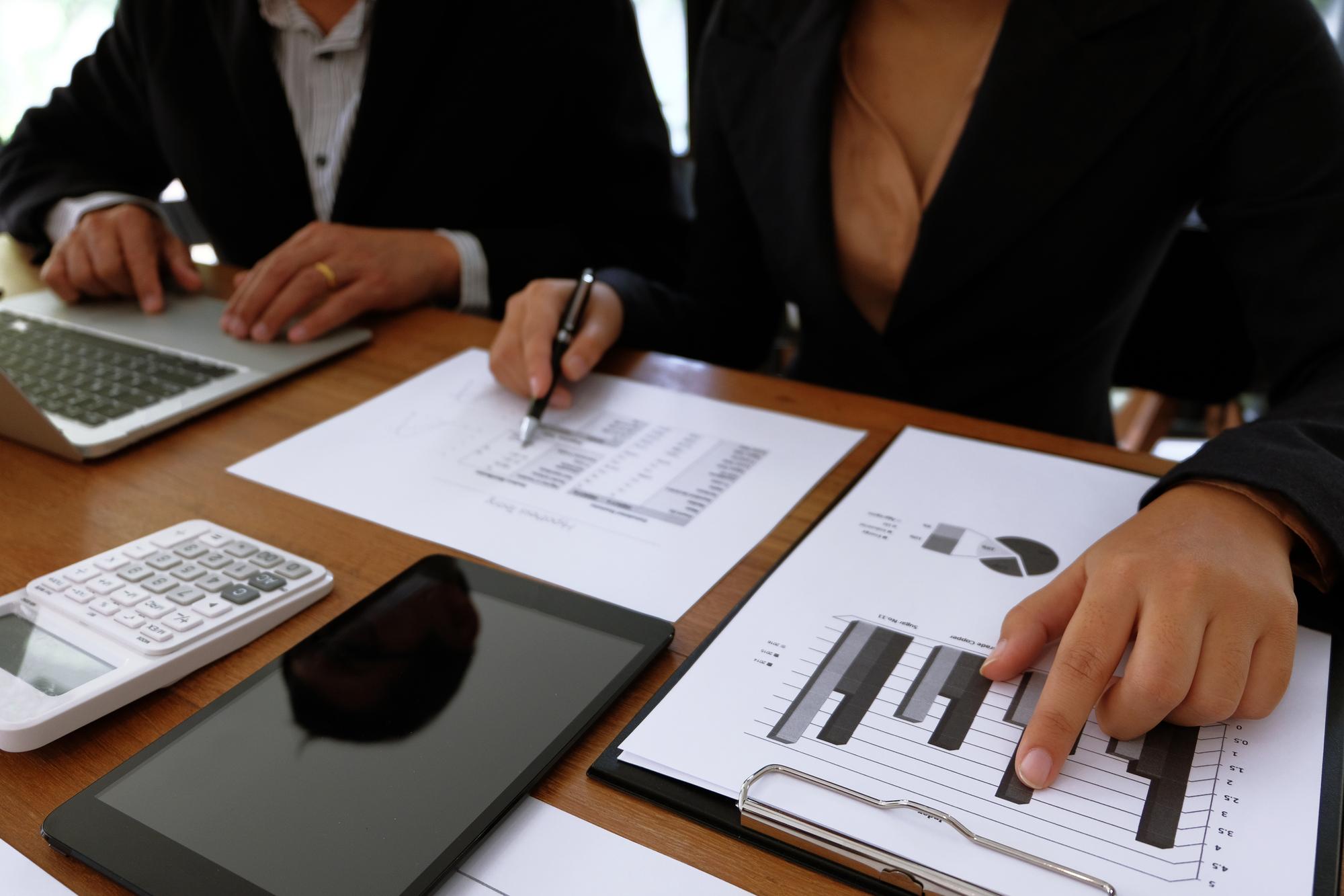 Colegas de trabalho a discutir documentos à mesa no escritório.