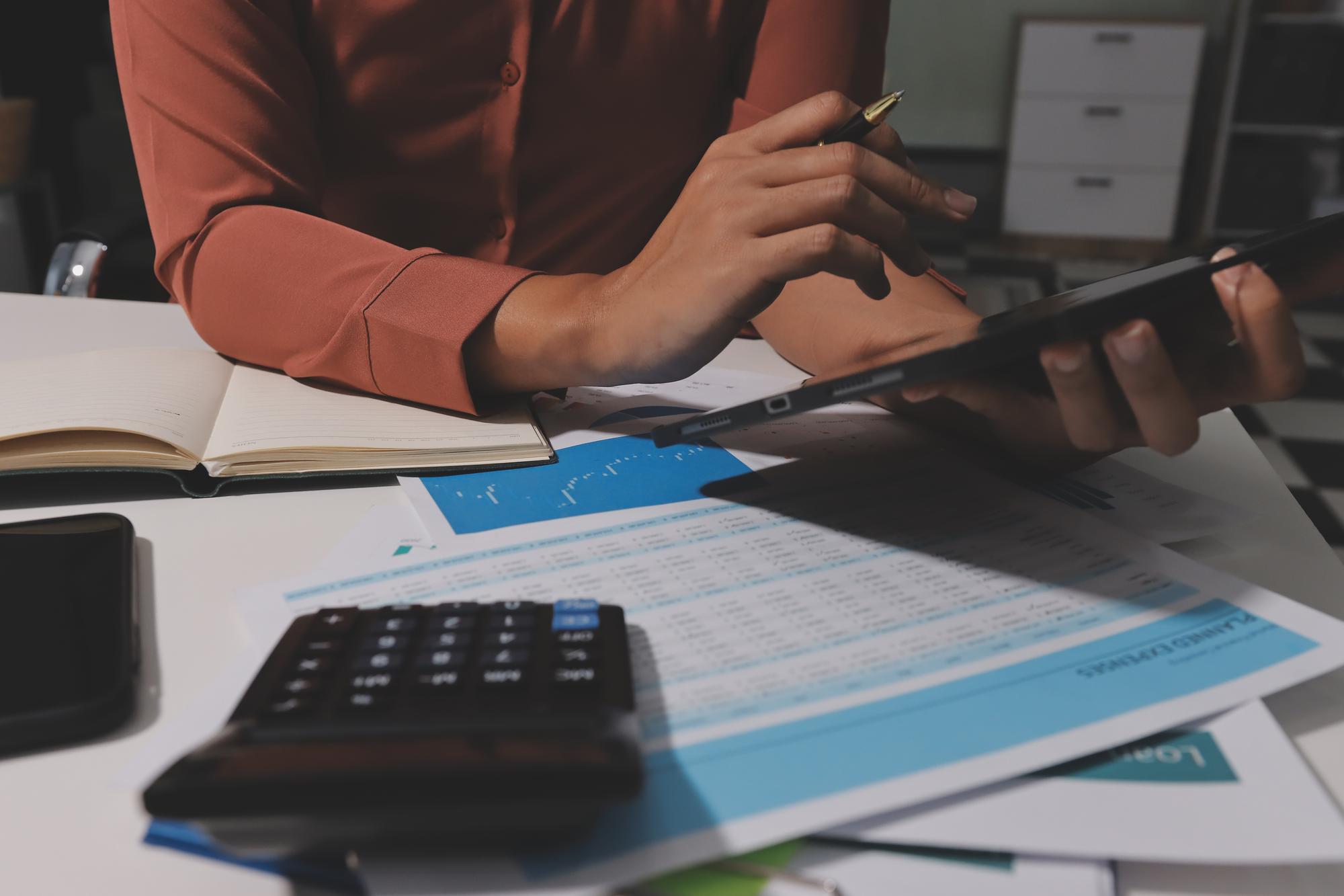 Trabalhando em casa Closeup mulher de negócios usando computador portátil e analisando relatório financeiro