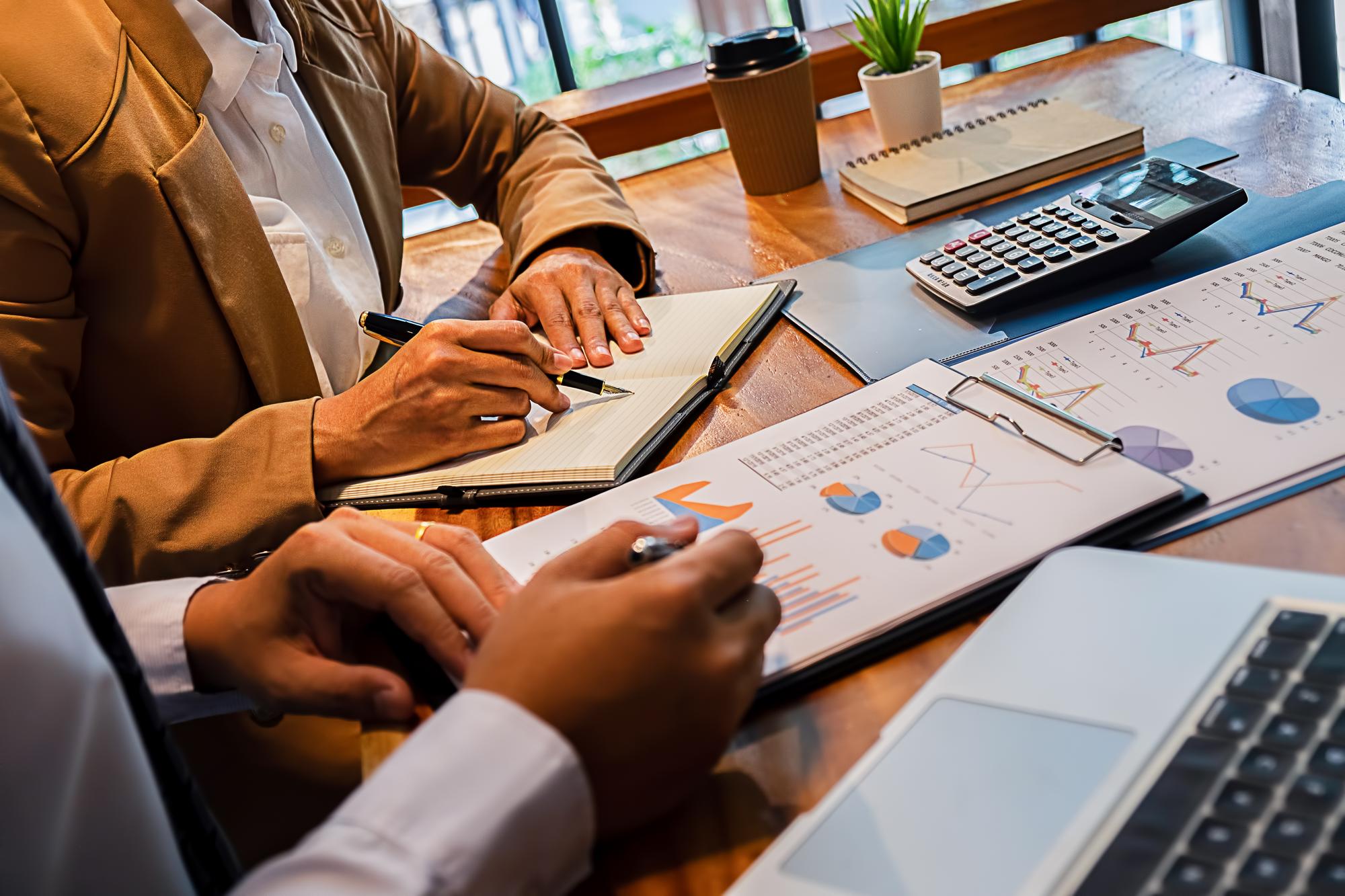 Midsection de pessoas de negócios analisando gráficos na mesa no escritório