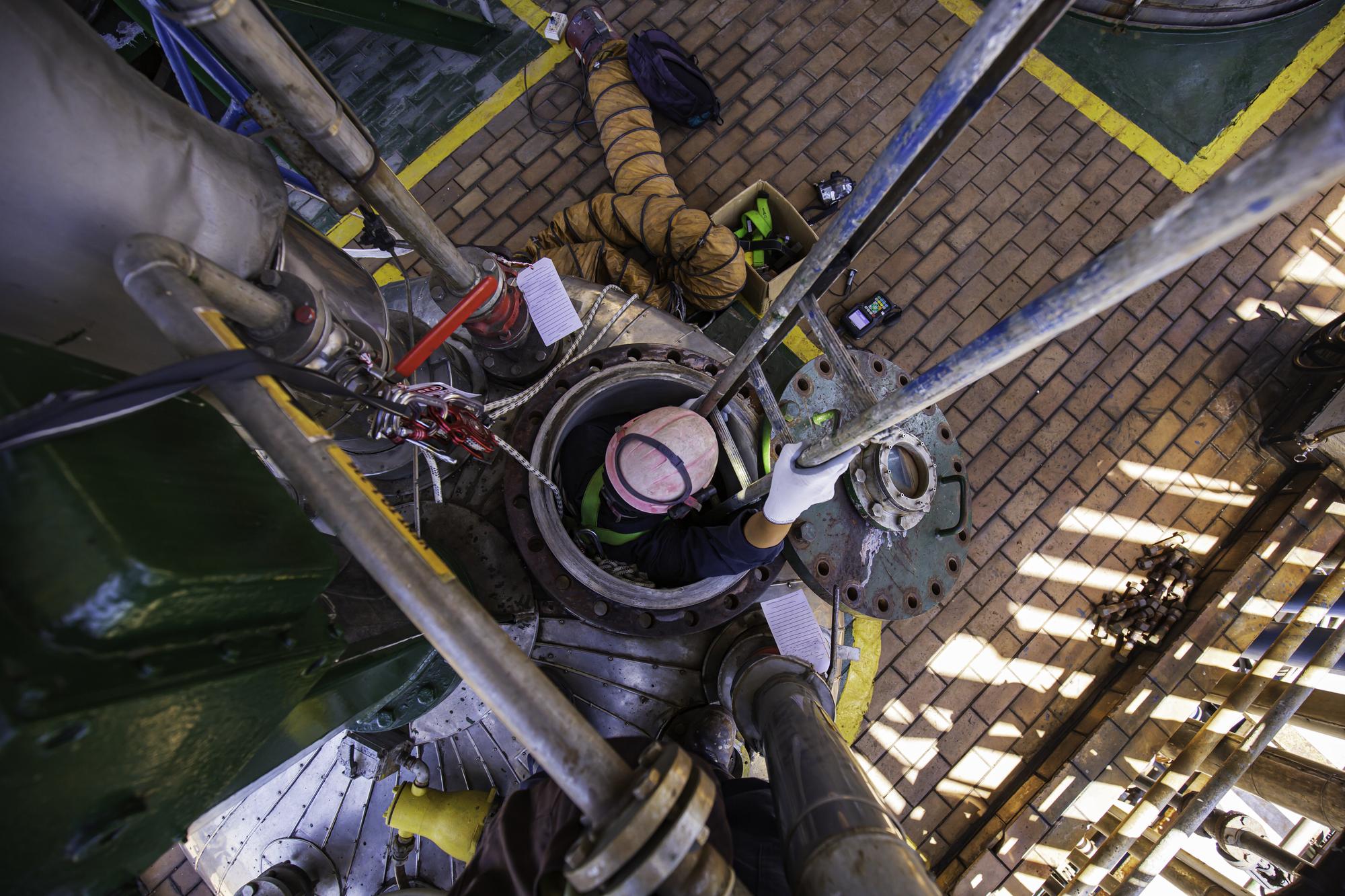 Macho em processo de inspeção de trabalho químico em tanque inoxidável químico