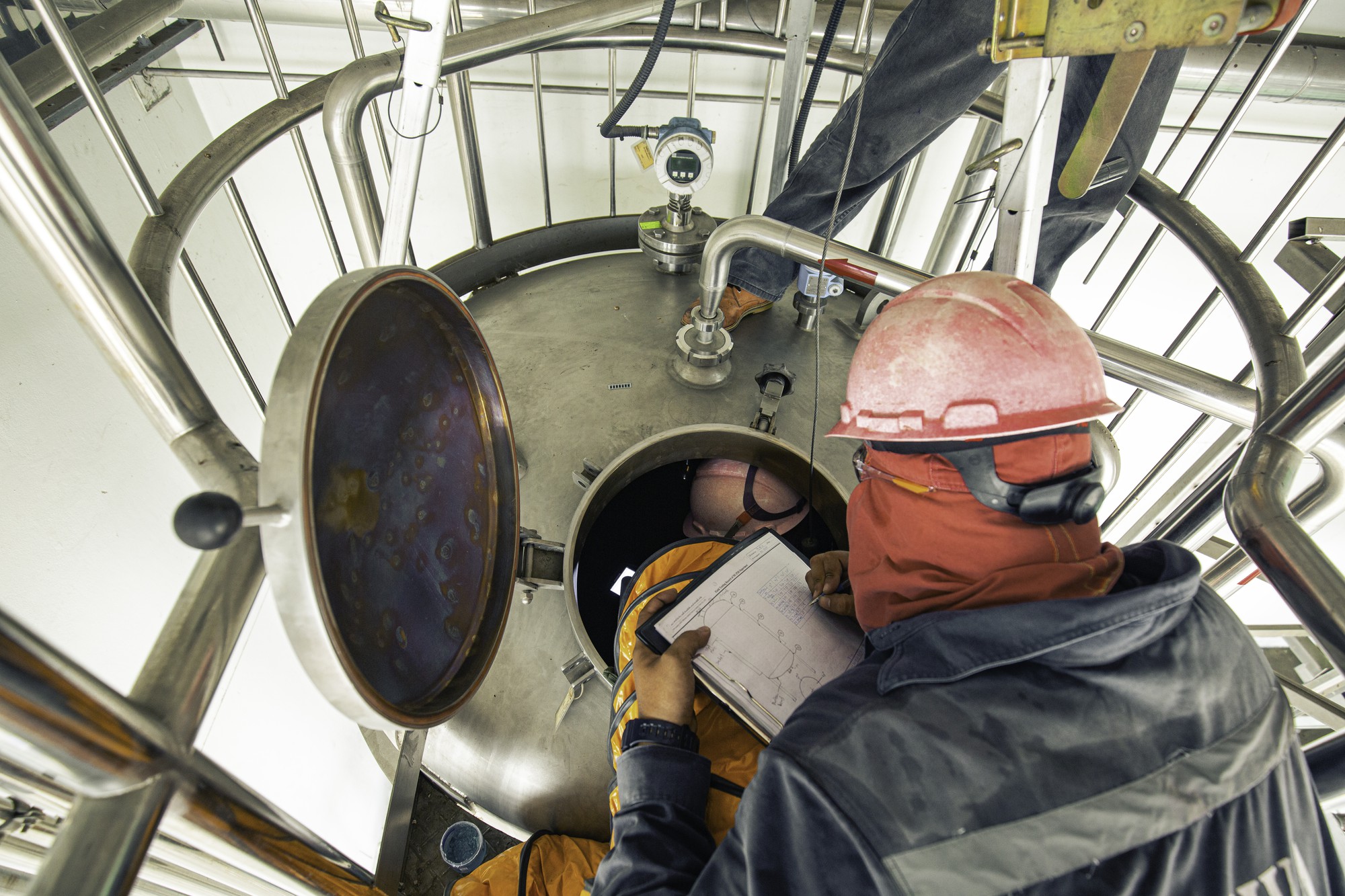 Vista superior do sexo masculino subir as escadas para a área de produtos químicos do tanque espaço confinado ventilador de segurança ar fresco