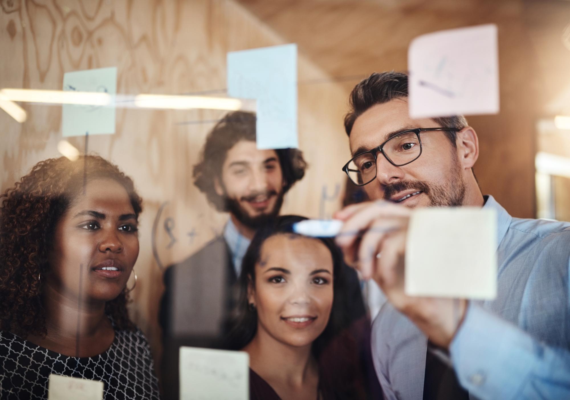 Empresário treinando e escrevendo com tabuleiro de vidro para planejamento de horários brainstorming ou trabalho em equipe no escritório Homem treinando colegas de equipe ou funcionários para estratégia de mapa mental ou tarefas no local de trabalho