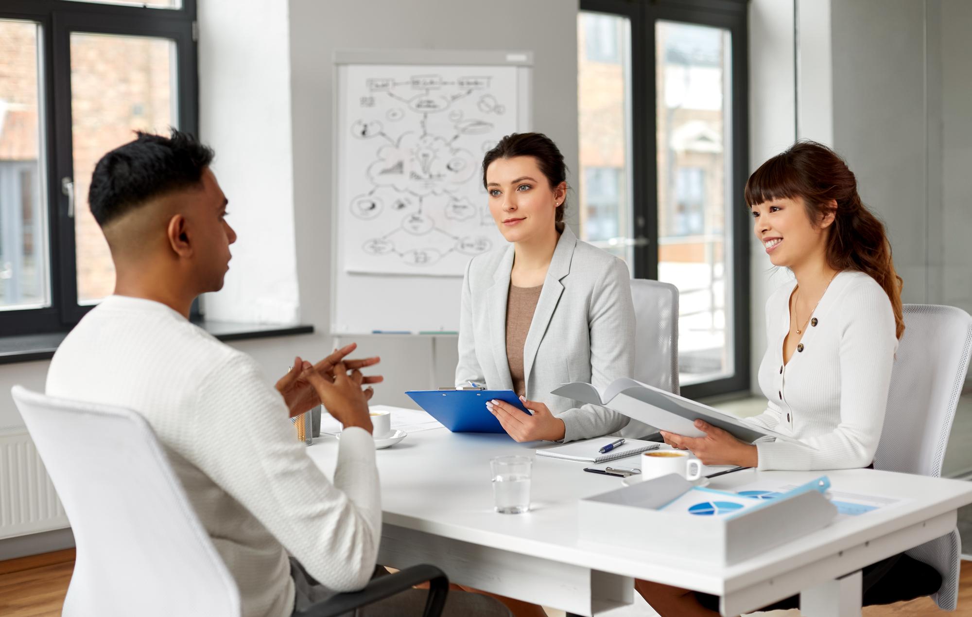 recrutadores a fazer uma entrevista de emprego com um empregado masculino