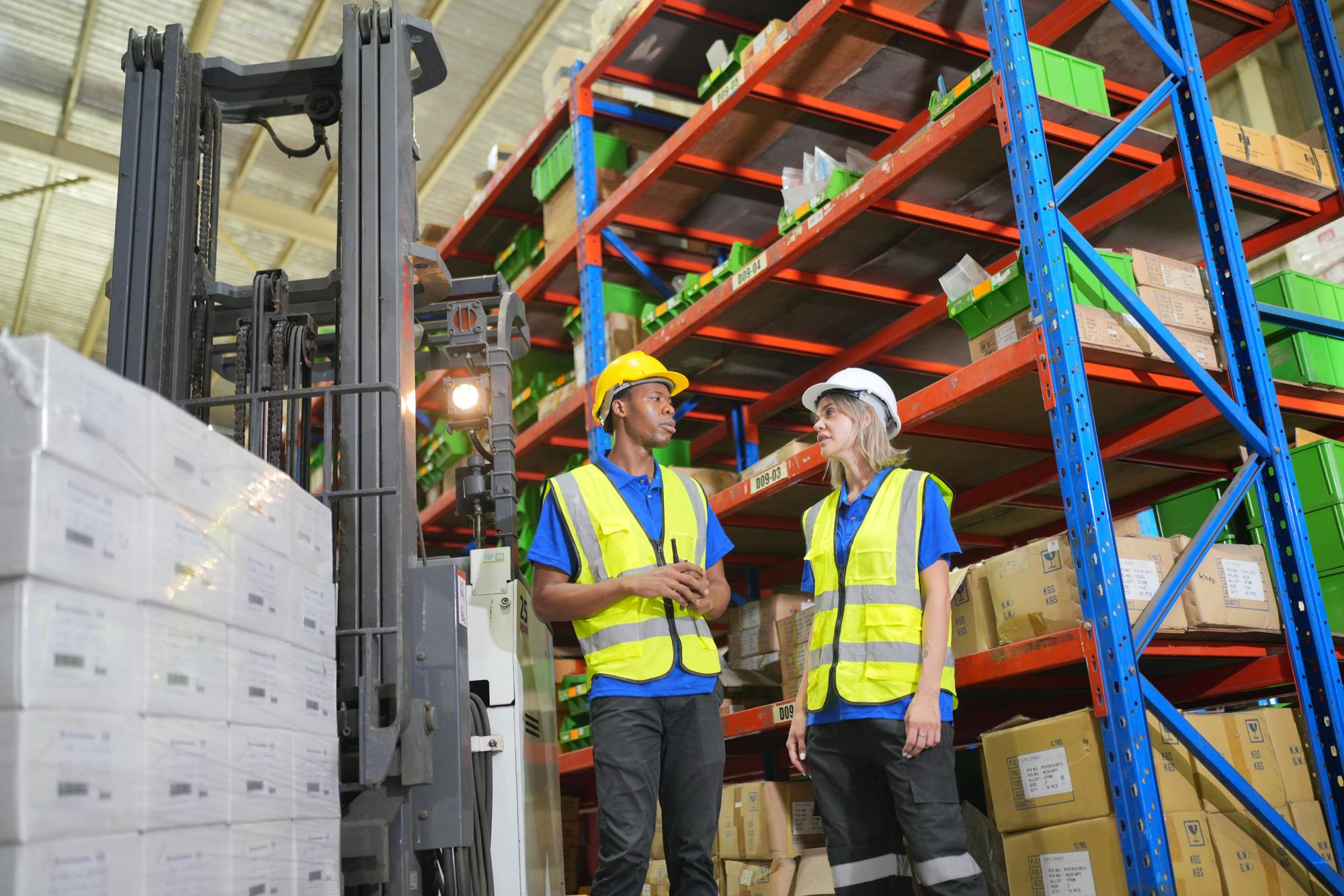Trabalhadores do armazém verificando o estoque Produtos no armazenamento de prateleiras de estoque Trabalhador fazendo inventário no armazém Despachante de uniforme fazendo inventário no conceito de cadeia de suprimentos do armazém