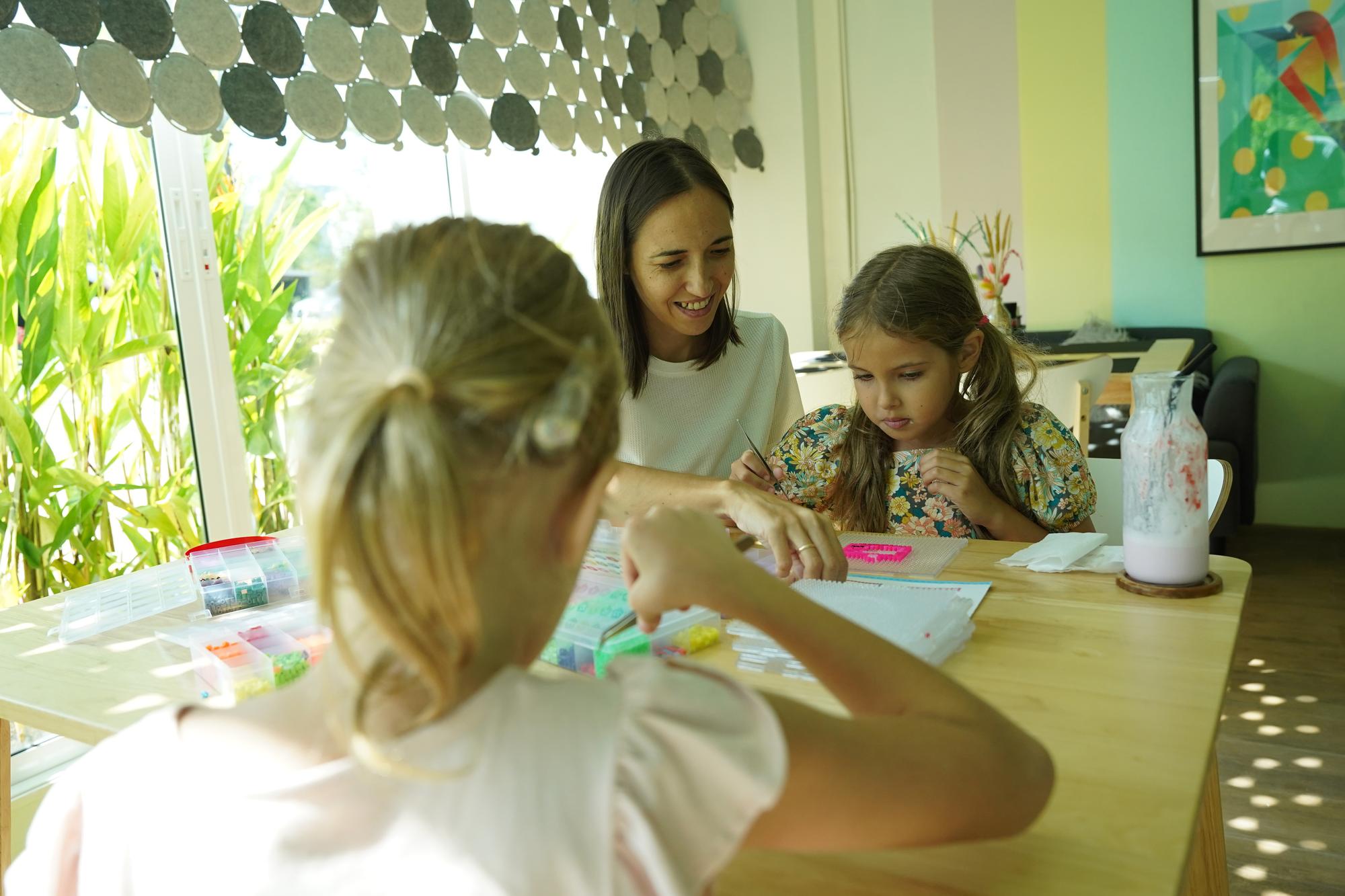 Professora na oficina ensinou duas meninas a montar um mosaico térmico