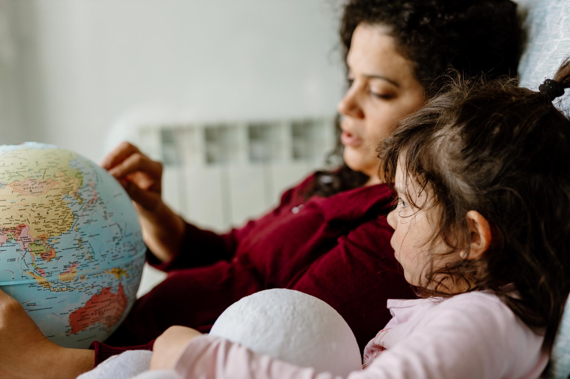 Mãe e filha a brincar com o globo terrestre