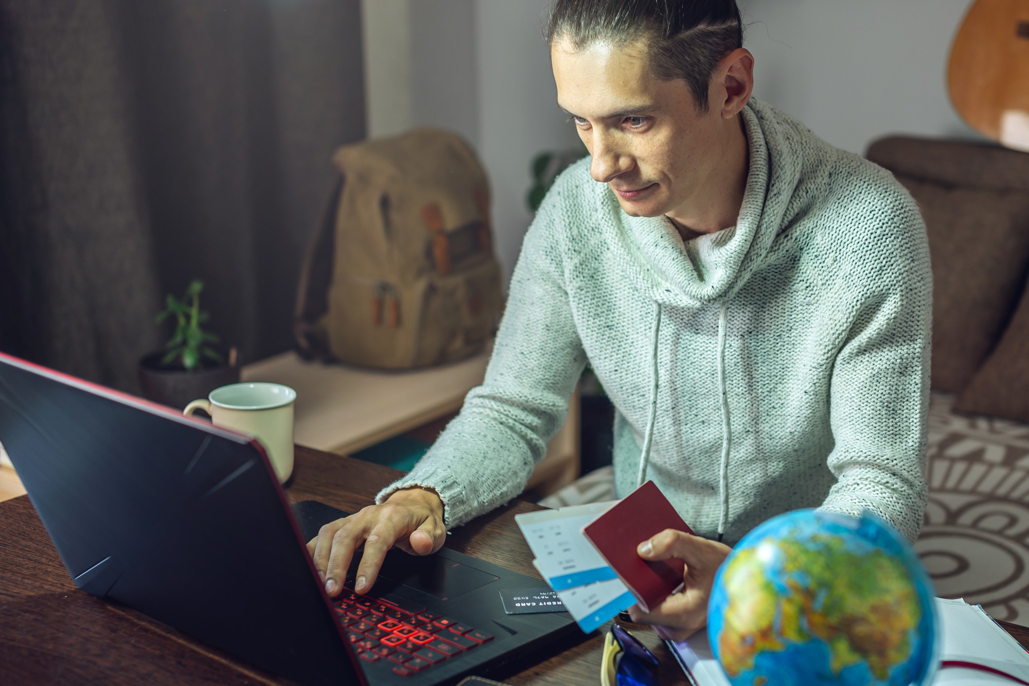 Um homem está comprando passagens aéreas pela Internet usando um laptop para uma viagem tão esperada